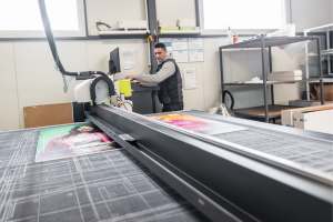 Machine Operator guiding printed signs
