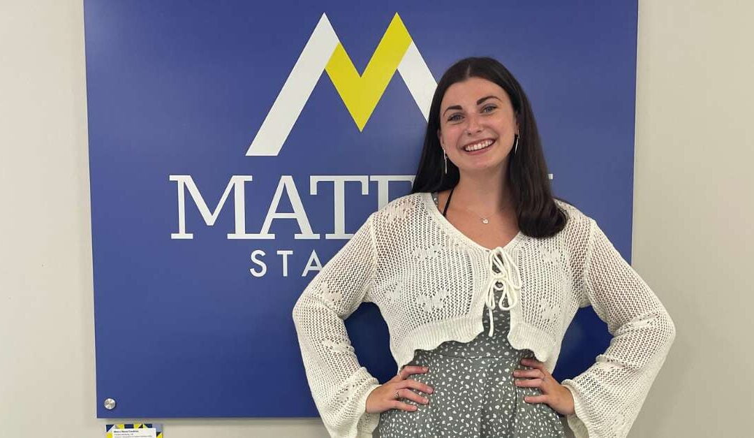 Intern Madi standing in front of matern Staffing sign
