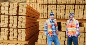 Delivery Helper standing in front of large supply of lumber
