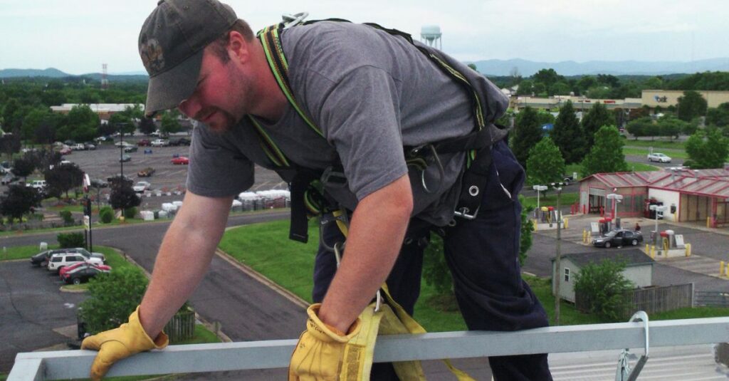 Matthew standing on top of a building doing maintenance