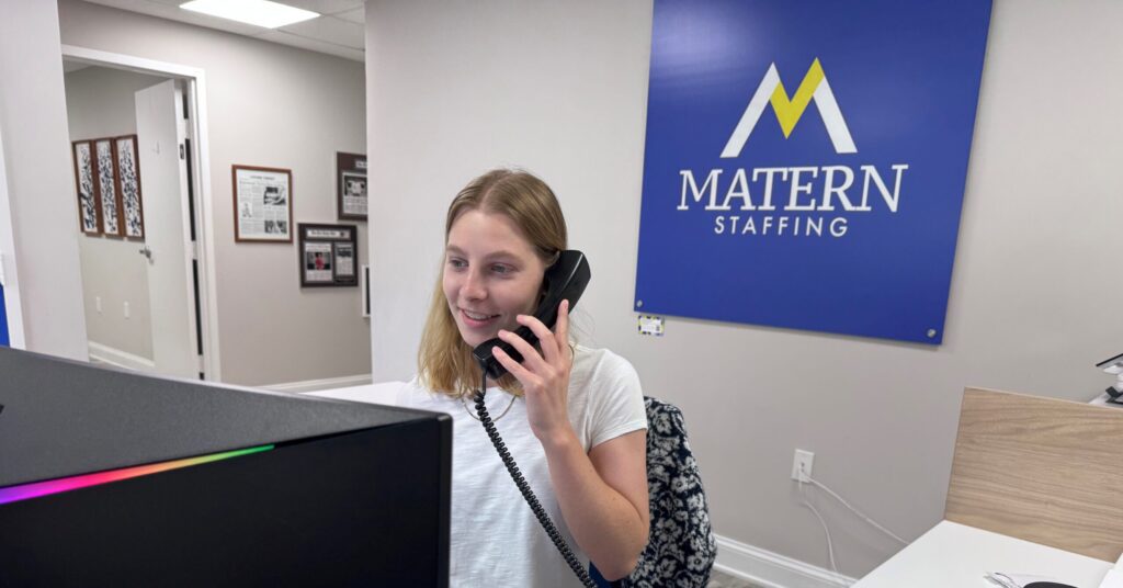 Intern confidently running the front desk while speaking on the phone, showcasing professionalism and strong communication skills.