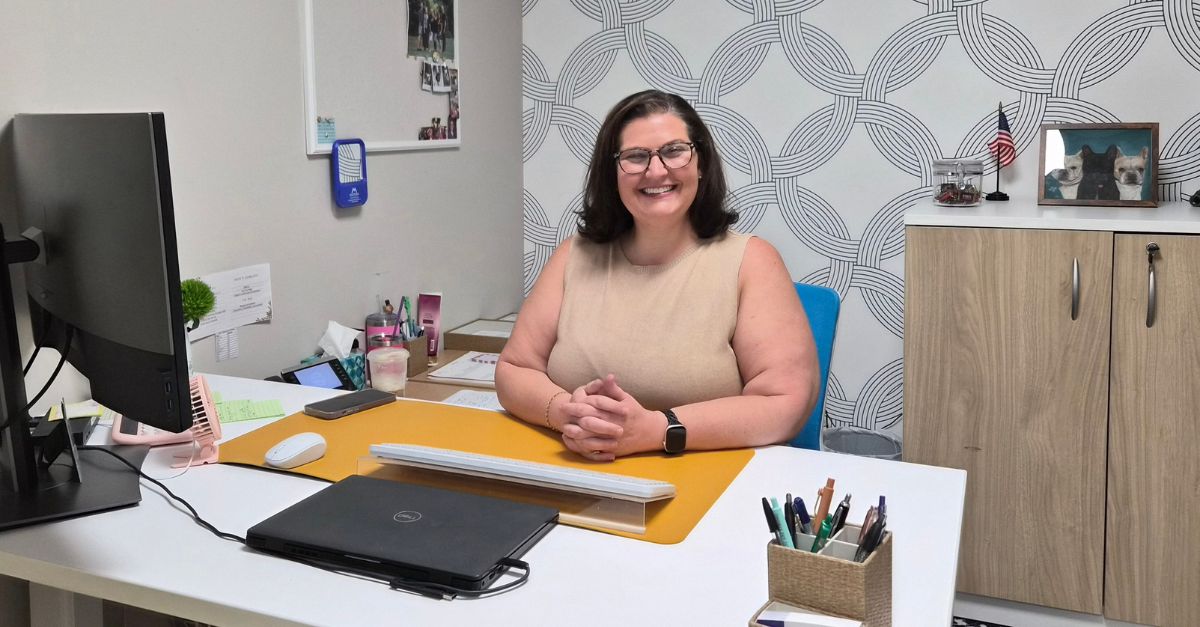 Glenda sitting at her desk.