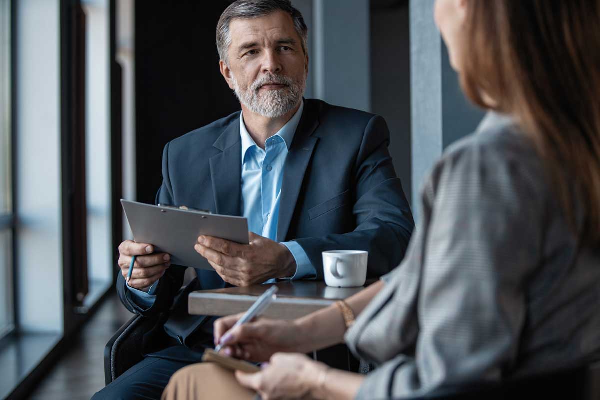 Image of mature businessman interviewing female. Image of mature businessman interviewing female.